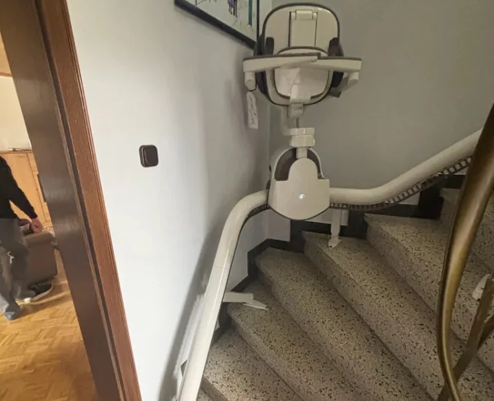 Treppenlift auf gewendelter Treppe mit Fliesenstufen
