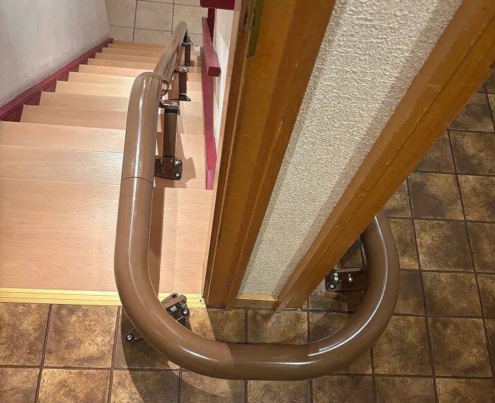 Kurvenschiene an einer hellen Holztreppe